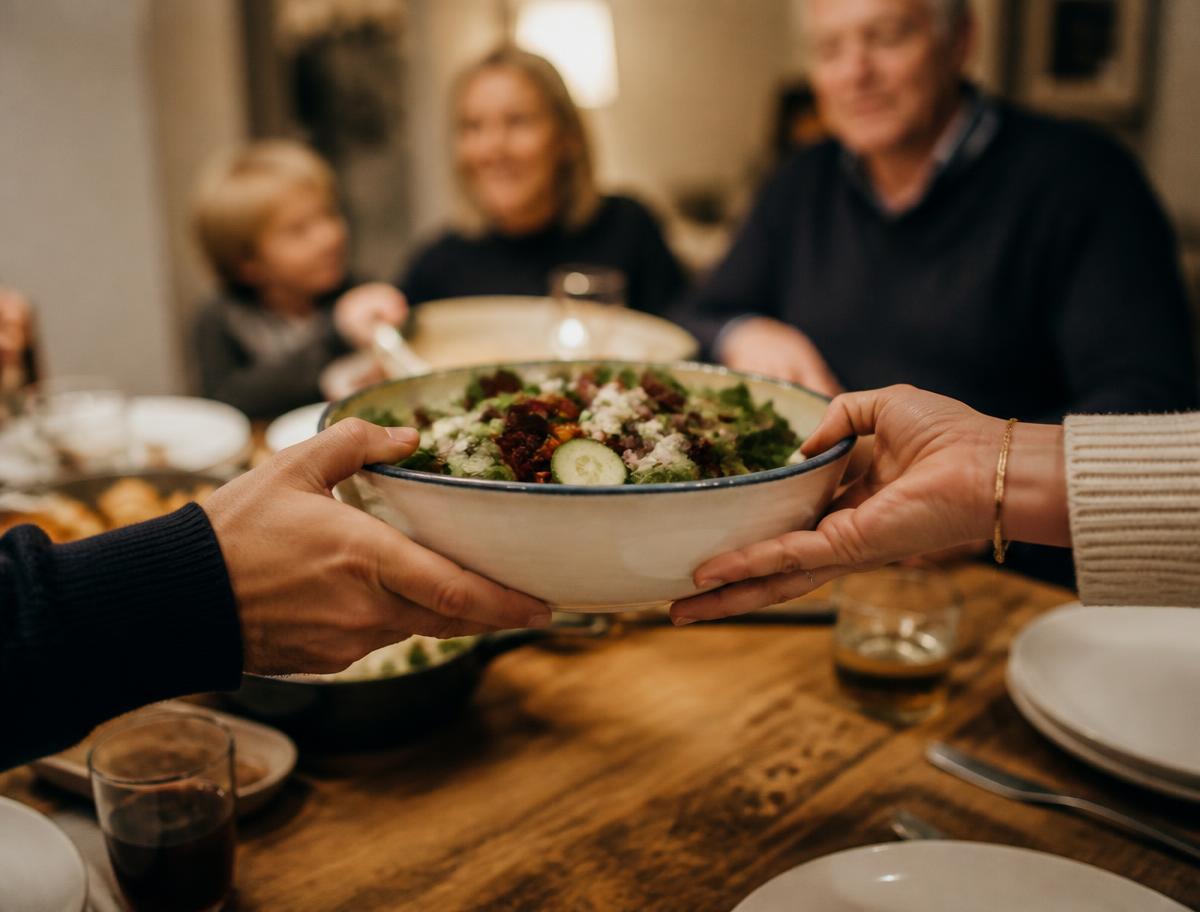 Two hands passing a bowl of warm food across a welcoming oak table