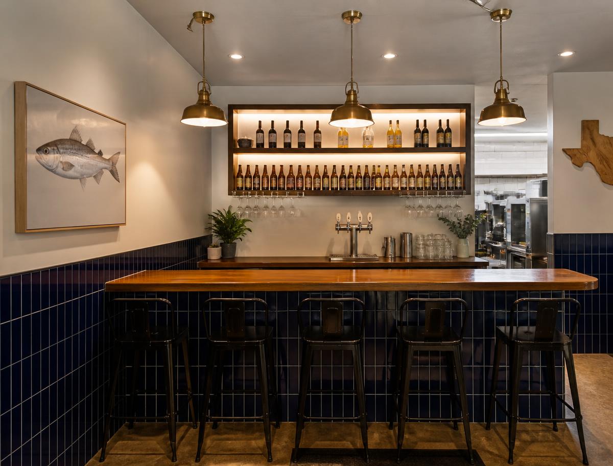 Little beer and wine bar inside a Neighborhood format FishNChips shop, six stools at an oak bar with three taps and a lit Texas beer and wine shelf